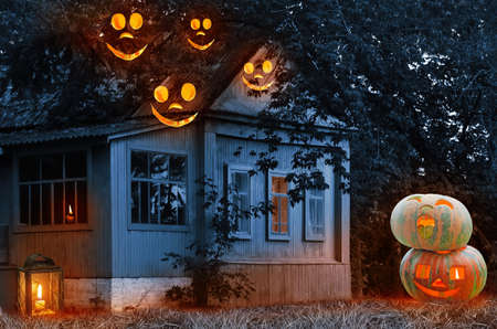 Creepy Halloween pumpkins in the grass outside the house, flying fire ghosts with toothy smiles