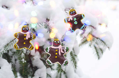 Christmas concept with gingerbread men on the background of a defocused Christmas tree and bokeh