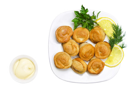 Fried ravioli with mayonnaise, herbs and lemon on a white plate. Top viewの写真素材