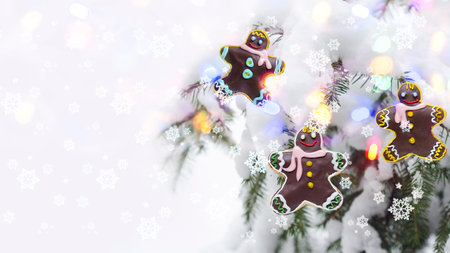 Christmas concept with gingerbread men on the background of a defocused Christmas tree and bokehの写真素材