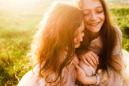 Little sisters walk in the green field