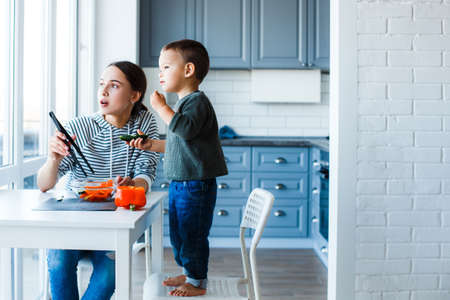 Mom and son prepare a salad in their kitchenの写真素材