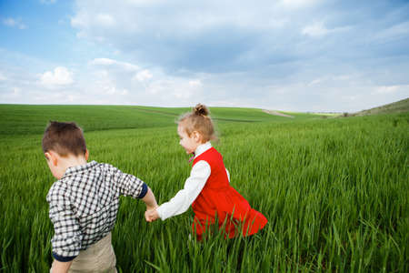 Little children running through the meadow.の写真素材