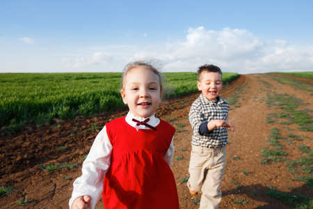 Happy children running in the meadowの写真素材
