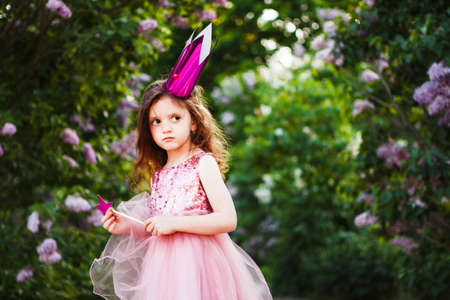 Portrait of a cute little girl with a princess crown making a sad faceの写真素材