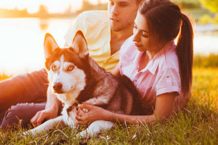 Lifestyle, happy family of two resting at a picnic in the park with a dog.の写真素材