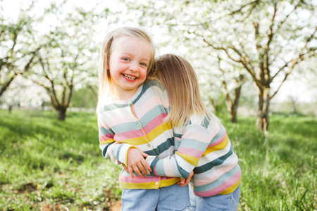 Little twins hug and laugh.の写真素材