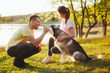 Lifestyle, happy family of two resting at a picnic in the park with a dog.の写真素材