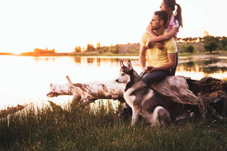 Lifestyle, happy family of two resting at a picnic in the park with a dog.の写真素材