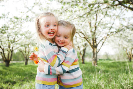 Little twins hug and laugh.の写真素材