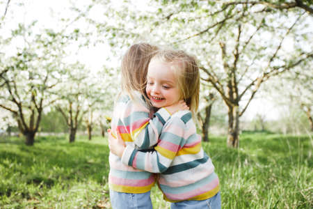 Little twins hug and laugh.の写真素材