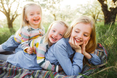 Group of happy children lying on green grass outdoors in summer parkの写真素材