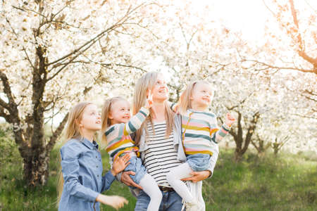 Mom and three daughters are walking in the park