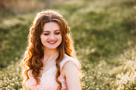 A girl in a beautiful dress strolls through a flowering gardenの写真素材