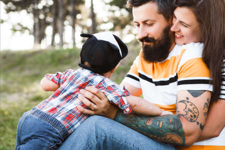 Hipster family, bearded dad with tattoos and stylish clothes.