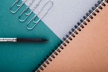A pencil, a pencil sharpener and crafting notebooks on a green-gray background.の写真素材