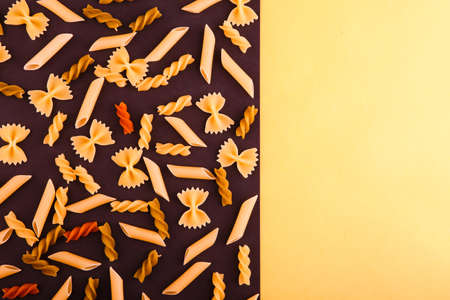 The assortment of various Italian raw pasta lay on a black background. Top view.の写真素材