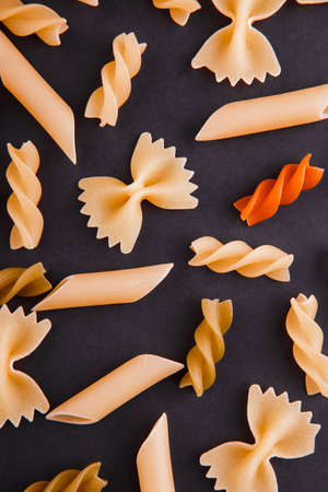 Assortment of variety of italian uncooked pasta flat lay on a black background.の写真素材