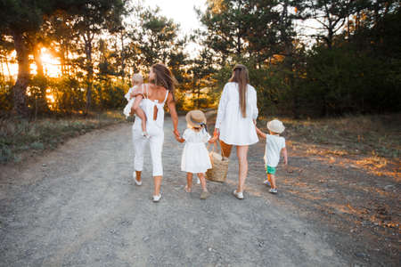 A large non-traditional family walks in the autumn forest.