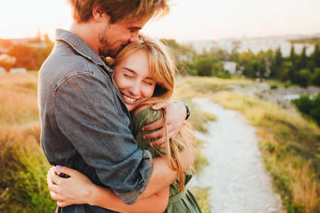 Happy young couple hugging and laughing outdoors.