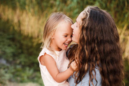 Ð¡urly mother and child are hugging and having fun outdoor in natureの写真素材
