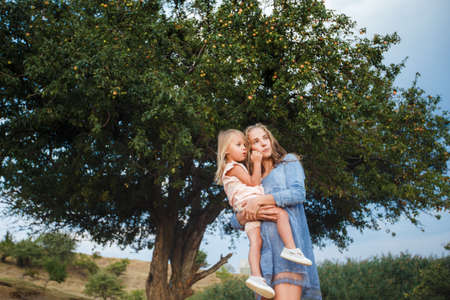 Ð¡urly mother and child are hugging and having fun outdoor in natureの写真素材