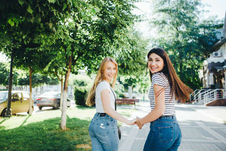 Two young girls hug and laugh.の写真素材