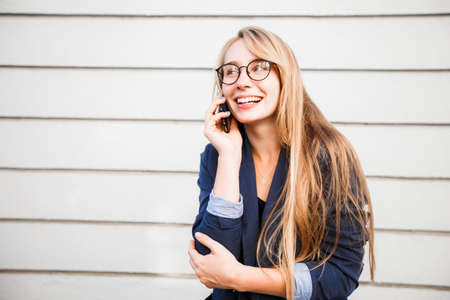 Young attractive caucasian gorgeous cheerful sweet smiling happy woman talking on the phone, copy space.の写真素材