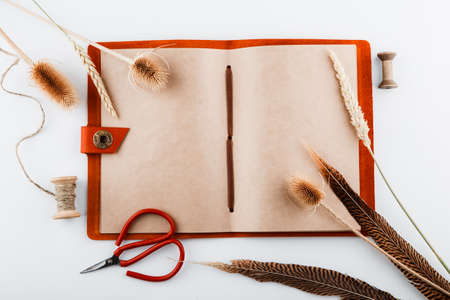 Vintage notepad with crafted pages. The composition of feathers and plants. Mockup. Space for text. Top view.の写真素材