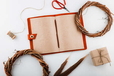 Vintage notepad with crafted pages. The composition of feathers and plants. Mockup.