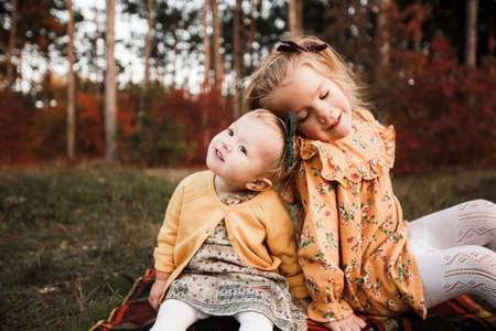 Young children walk in the autumn forest in retro dresses.の写真素材