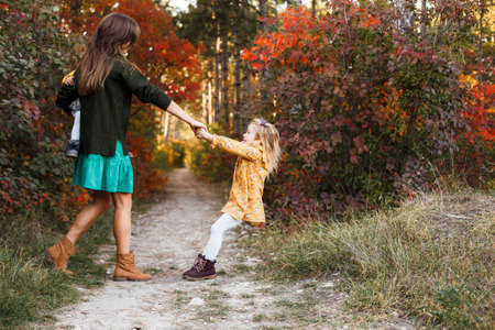 Beautiful young mother and her little daughter walking in summer park. Woman and cute kid girl spending time together. Happy family , sunny dayの写真素材