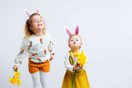 Happy easter. Funny children with rabbit ears celebrate Easter. Light gray background.