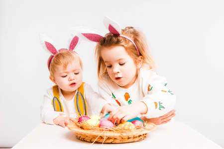 Happy easter. Funny children with rabbit ears celebrate Easter. Light gray background.