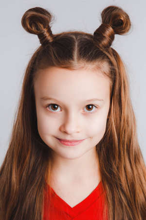 Emotional happy teen girl wearing a red t-shirt and horns shaped hair.の写真素材