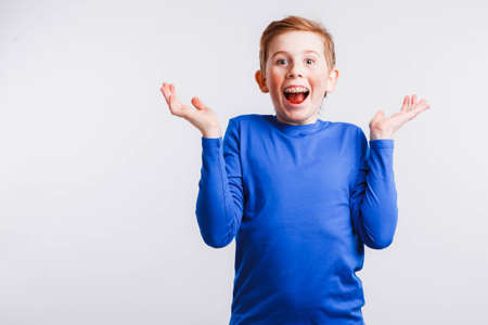 Red-haired nerd with braces and glasses on a white background.の写真素材