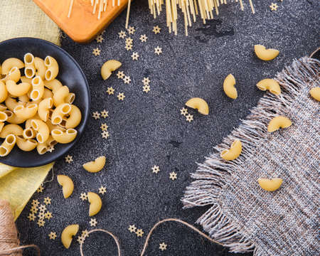 Pasta background. On a black wooden background. Free space for text . Top viewの写真素材