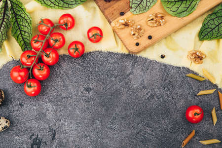 Halved Juicy Cherry Tomatoes and Basil Leaves on a black slate. Cherry tomatoes and herbs on a black slate. Concept for healthy nutrition. Top view. Copy space. Beautiful detox menu layout.の写真素材