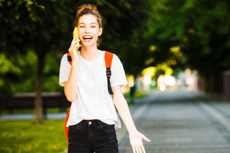 Traveler girl with orange backpack in the summer city.の写真素材