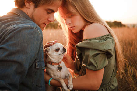 Young couple resting in nature with a little doggie.の写真素材