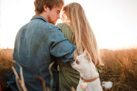 Young couple resting in nature with a little doggie.の写真素材