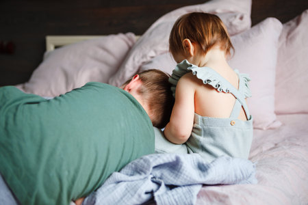 The little sister plays with her older brother at home.の写真素材