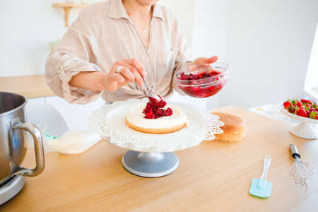 A pastry chef bakes a cake in the home kitchen. Home business.
