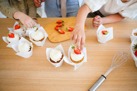 Mom and daughter are baking a beautiful dessert with cream.の写真素材