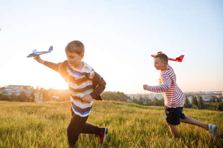 School-age boys launch a toy airplane.