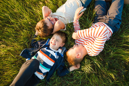 School-age boys lie on the grass.の写真素材