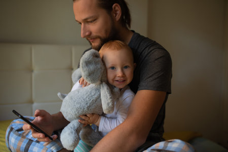 Dad and child are watching content on the phone. home rest.