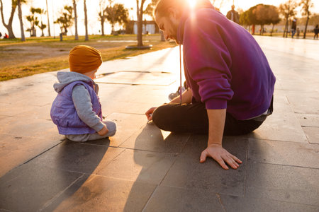 Dad and child draw with chalk on the pavement. autumn day.の写真素材