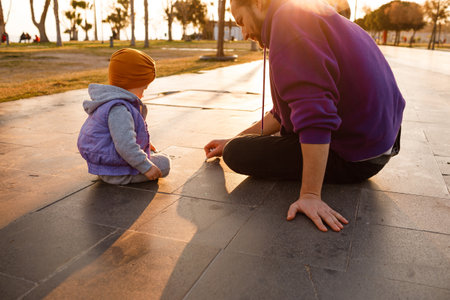 Dad and child draw with chalk on the pavement. autumn day.の写真素材
