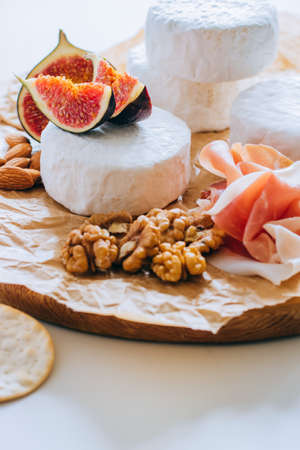 Camembert cheese, figs, jamon, honey and grapes. Cheese plate on marble backgroundの写真素材
